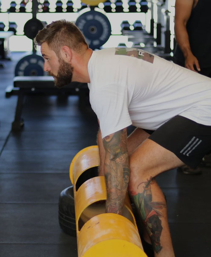 Personal trainer assisting client with weightlifting form