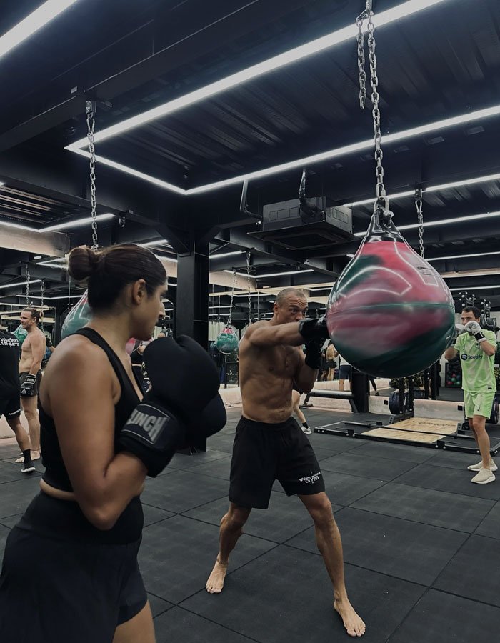 Personal trainer assisting client with weightlifting form