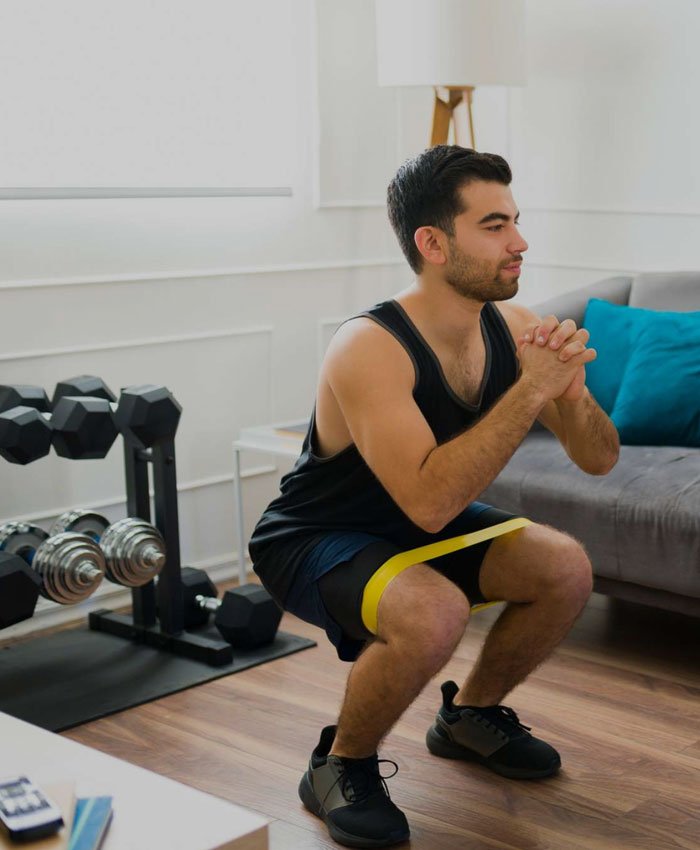 Personal trainer assisting client with weightlifting form